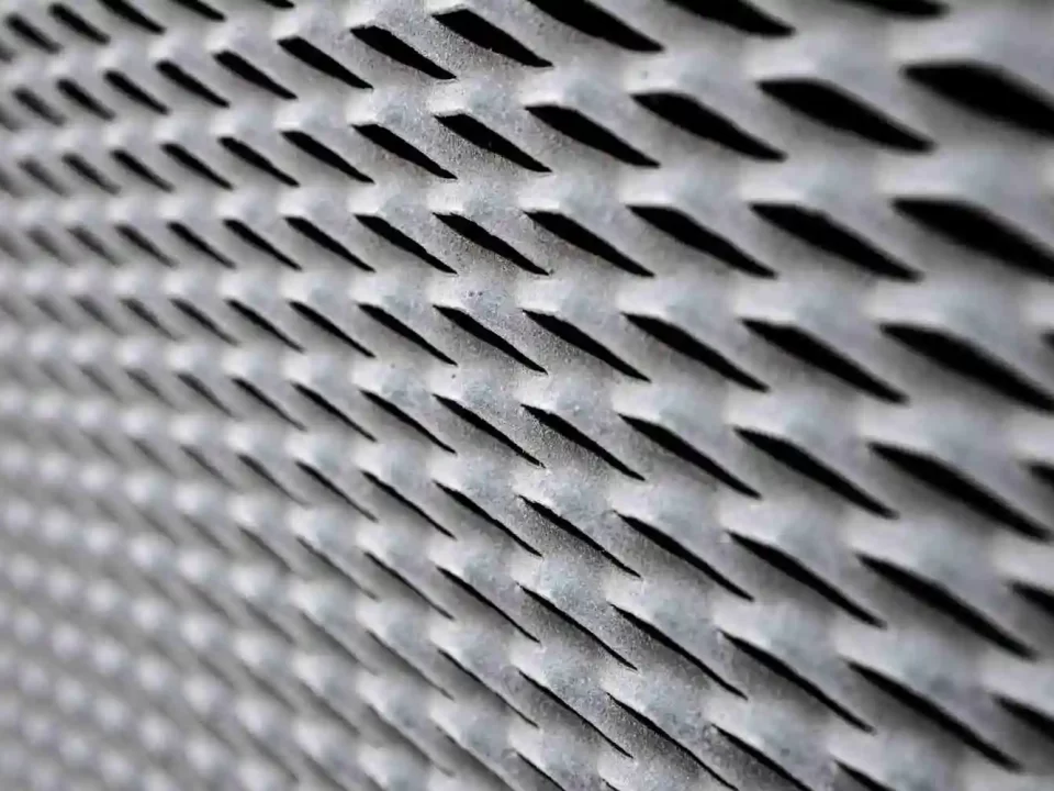 Imagem de uma grade feita de metal cheio de furos.